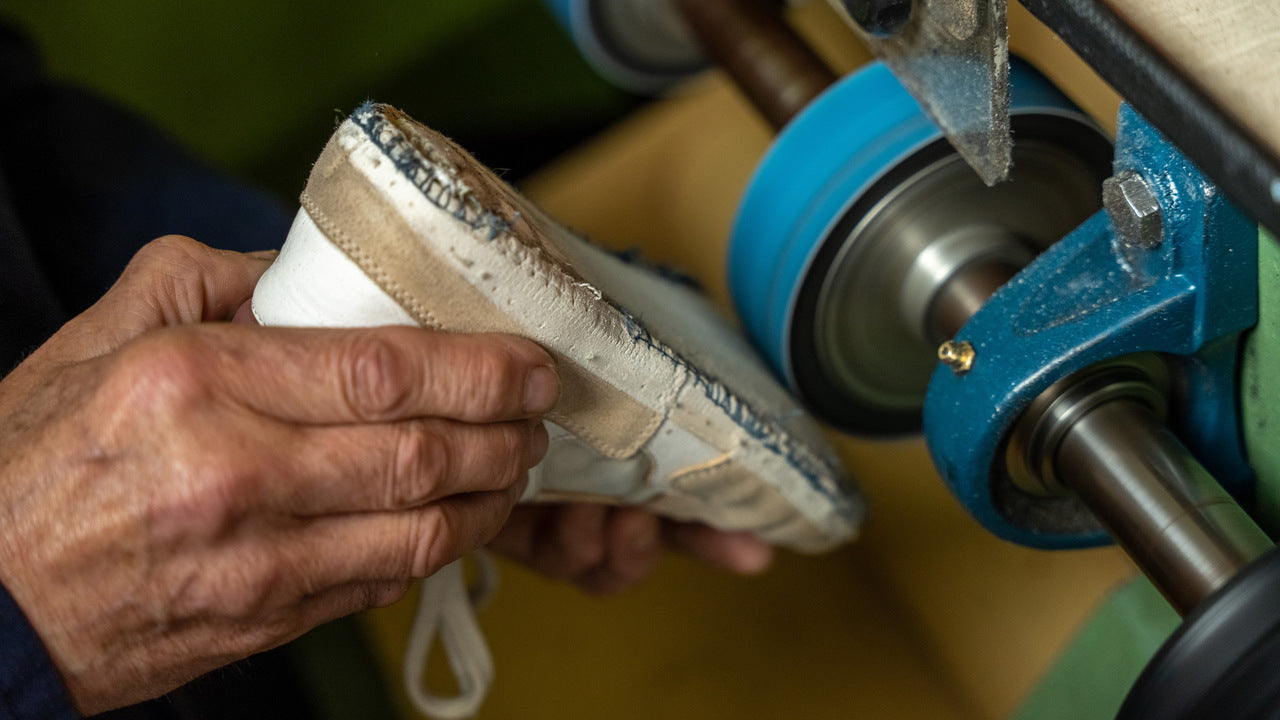 the outsole of the sonder white grey dry rose sneaker being repaired