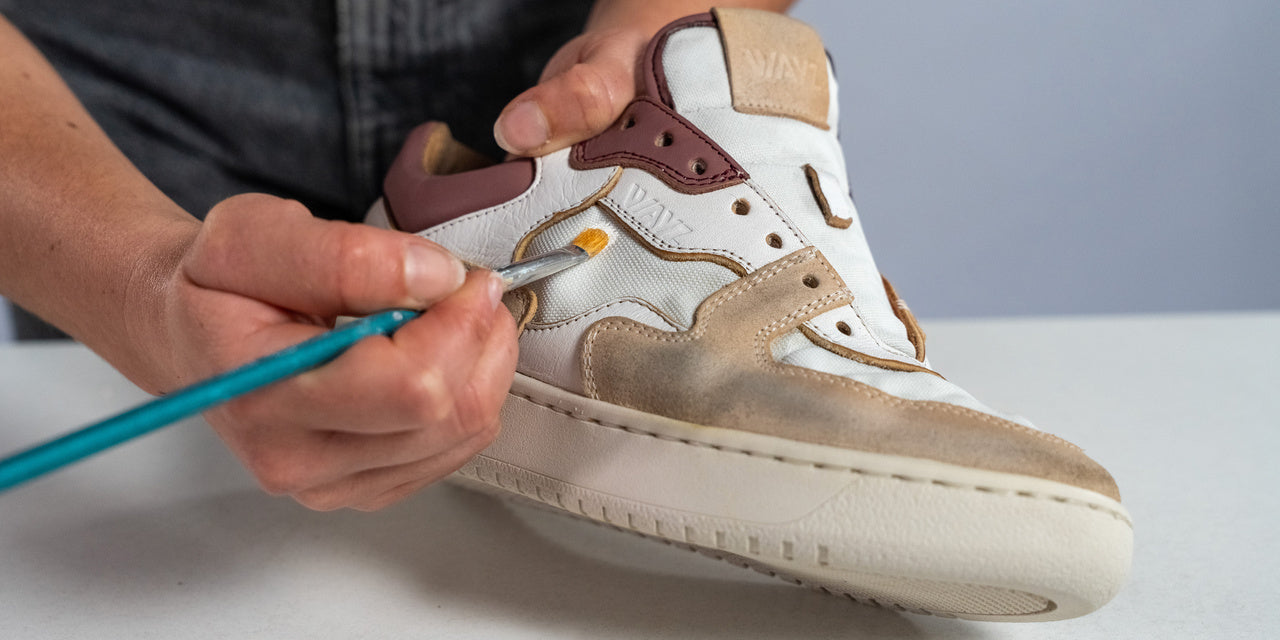 a person painting the sonder white grey dry rose sneakers with a brush