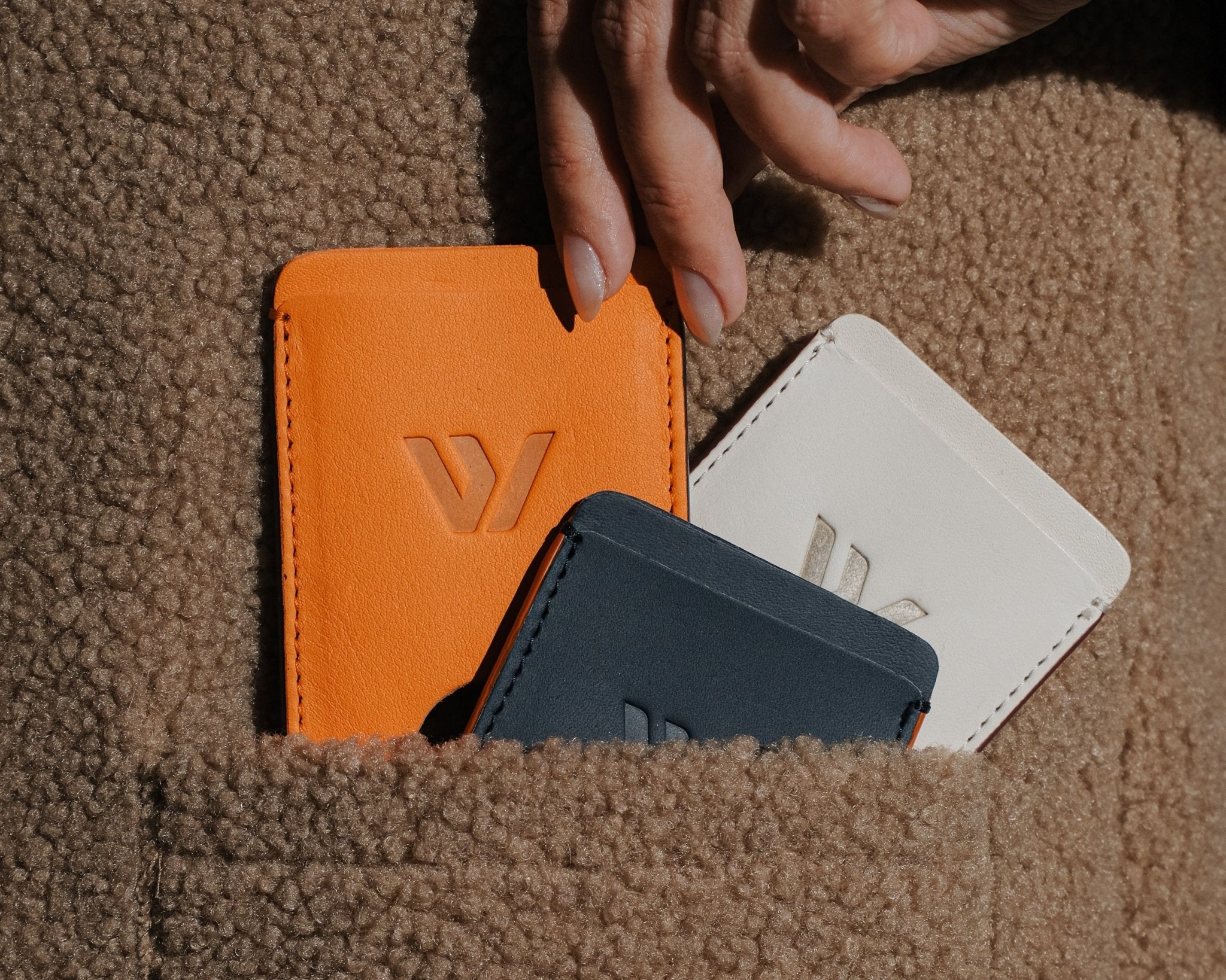 Wayz Card Holder all colours inside a pocket with hands picking it