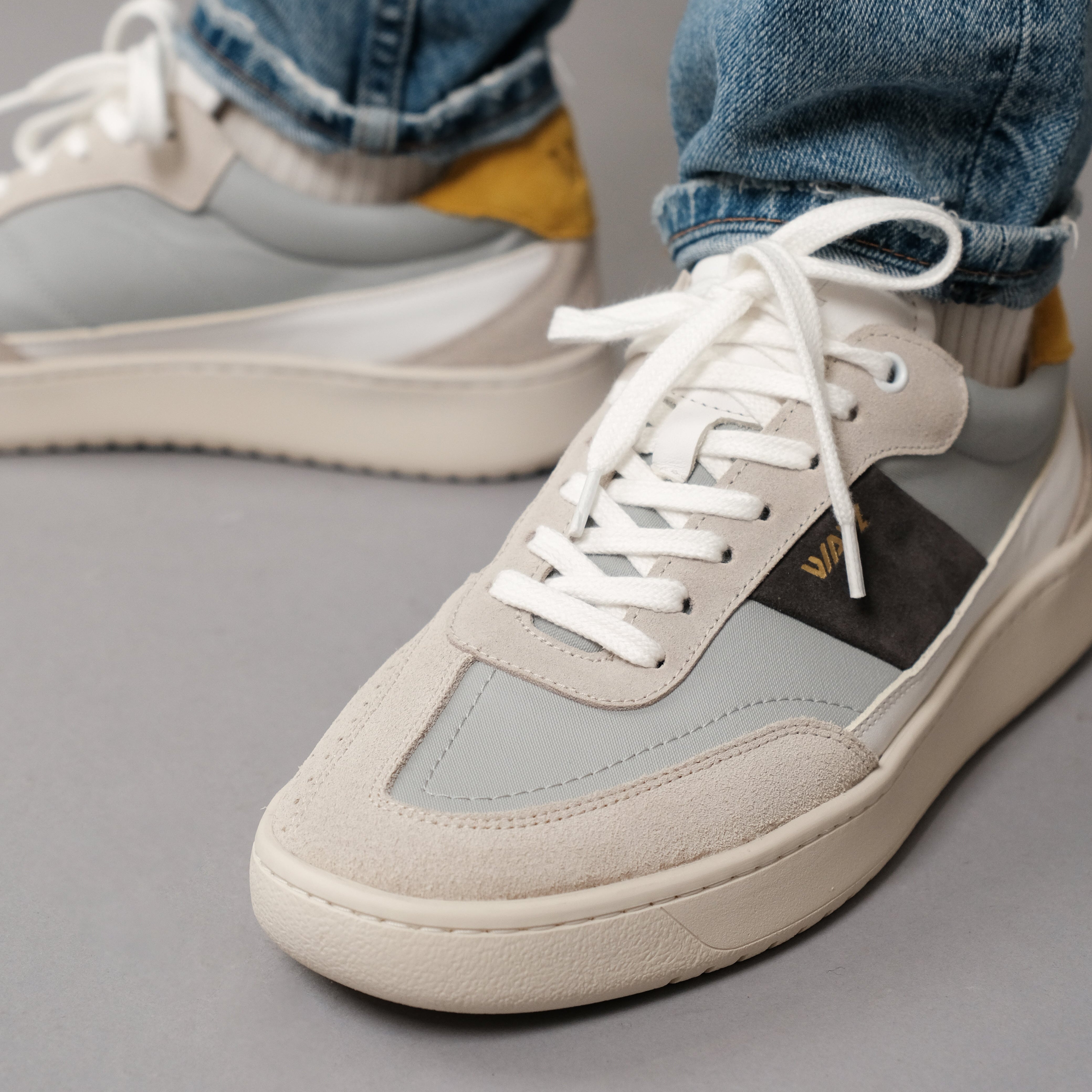 Wayz Spark white Grey Yellow sneakers facing on side on a grey background