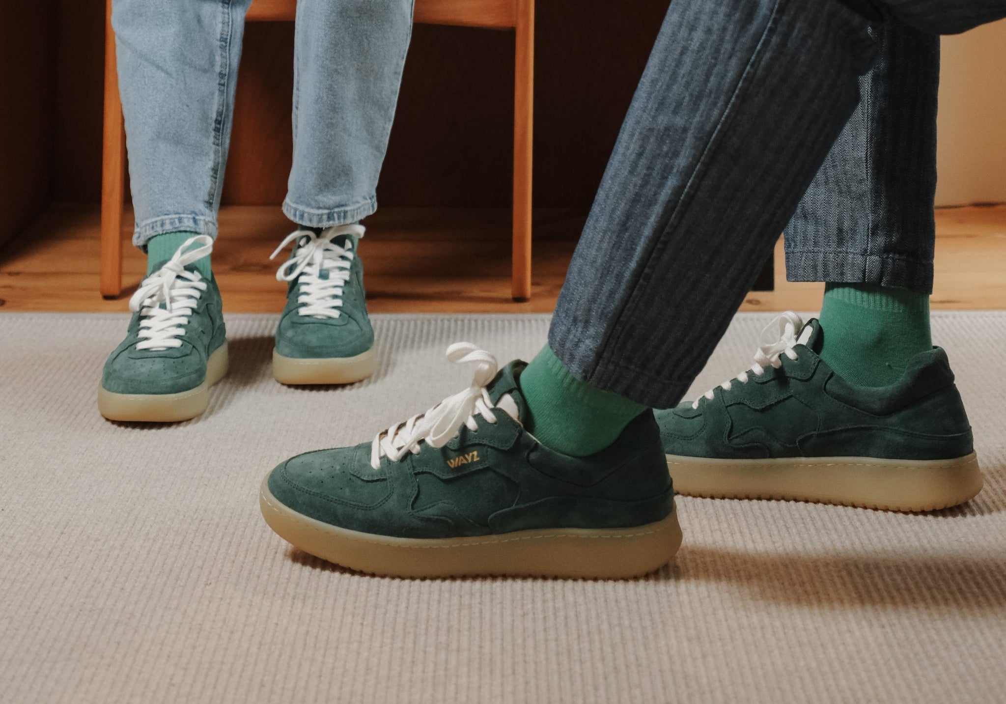 Wayz Sonder Pine Green sneakers facing side and front on top of a carpet