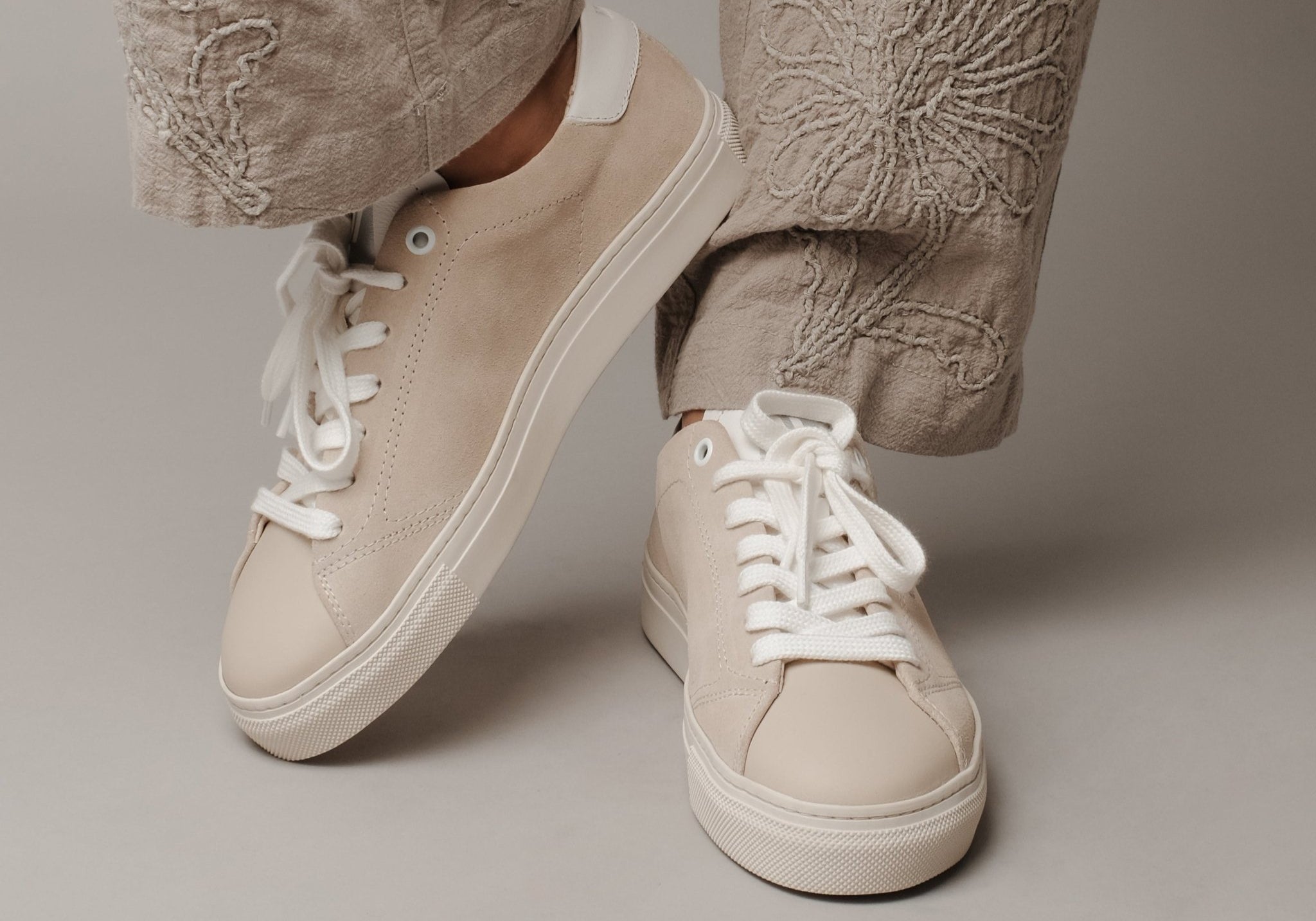 WAYZ Grit beige sneakers pose on grey background.