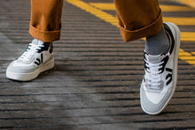 Load image into Gallery viewer, Person wearing our White Grey Black Veg-Tan Leather Misfit Sneakers - Front View
